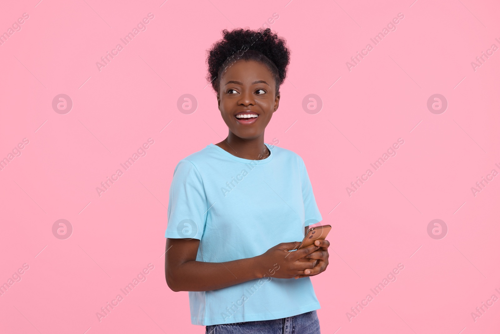 Photo of Happy young woman with smartphone on pink background