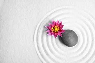 Photo of Zen garden. Beautiful lotus flower, stone and space for text on white sand, flat lay