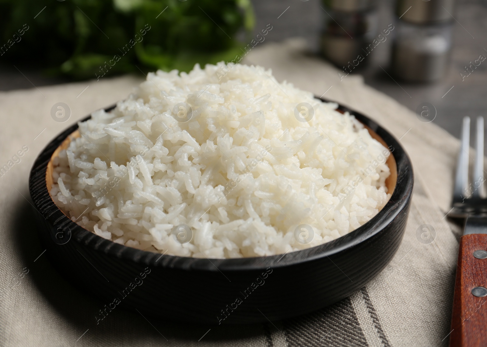 Photo of Boiled rice in bowl on napkin, closeup