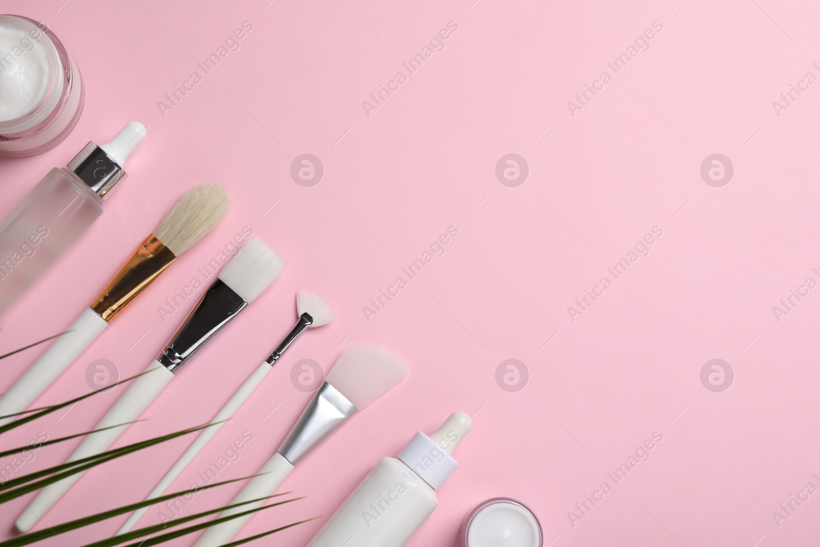 Photo of Different skin care products and brushes on pink background, flat lay. Space for text