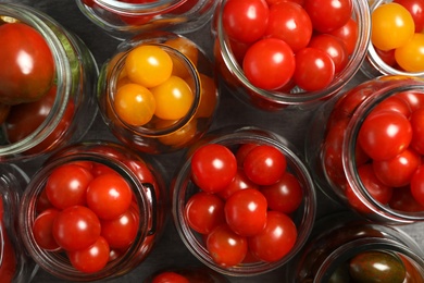 Pickling jars with fresh tomatoes, flat lay