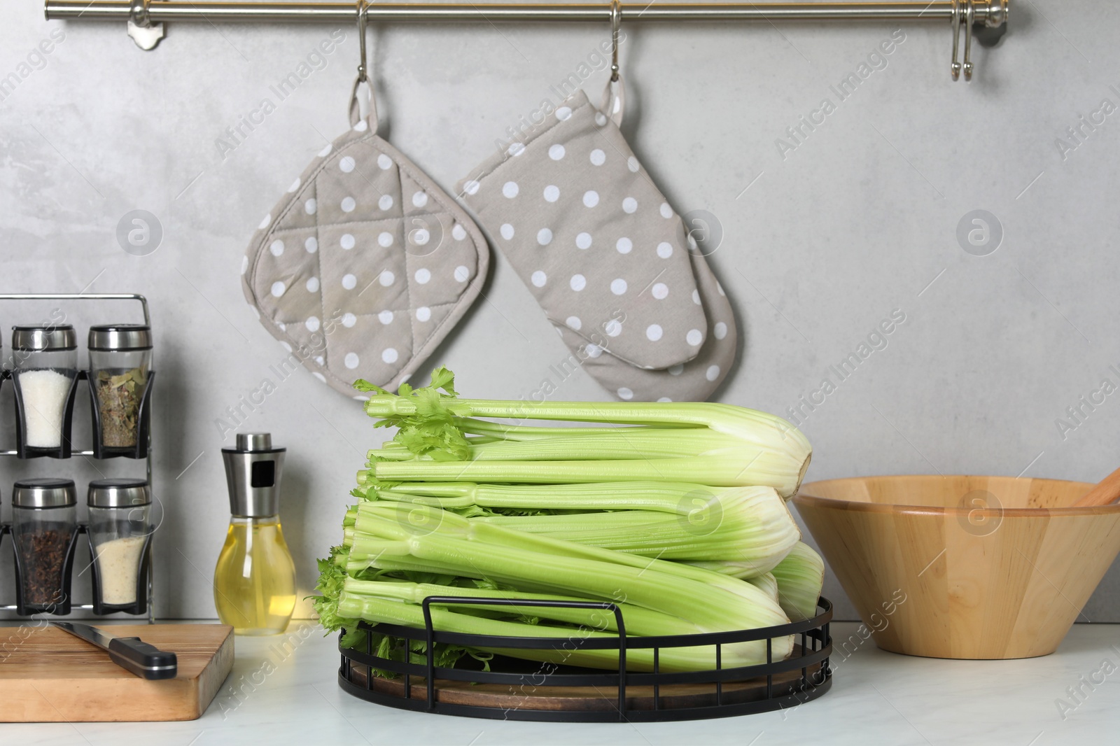 Photo of Fresh ripe green celery on white table in kitchen