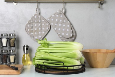 Fresh ripe green celery on white table in kitchen