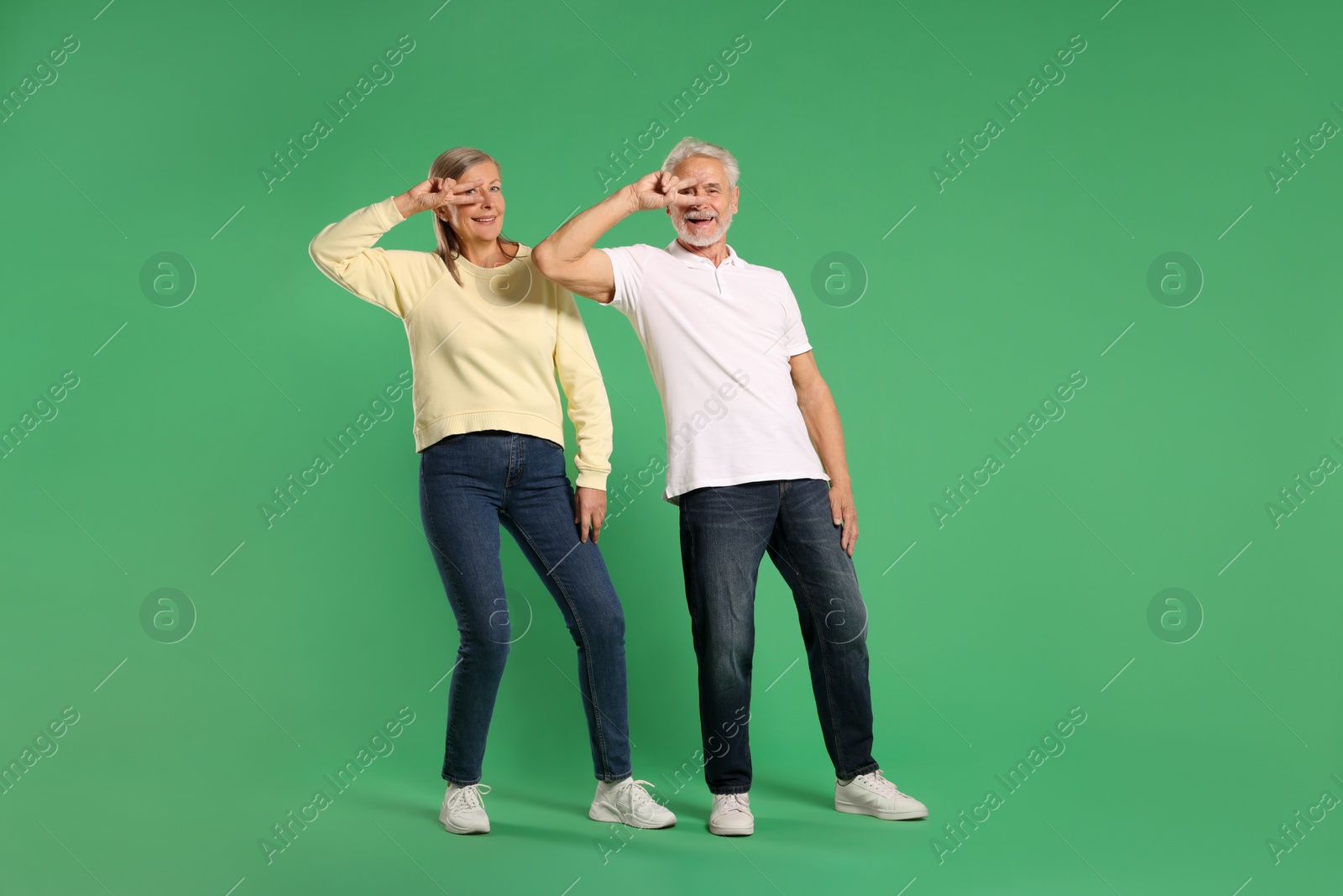 Photo of Senior couple dancing together on green background