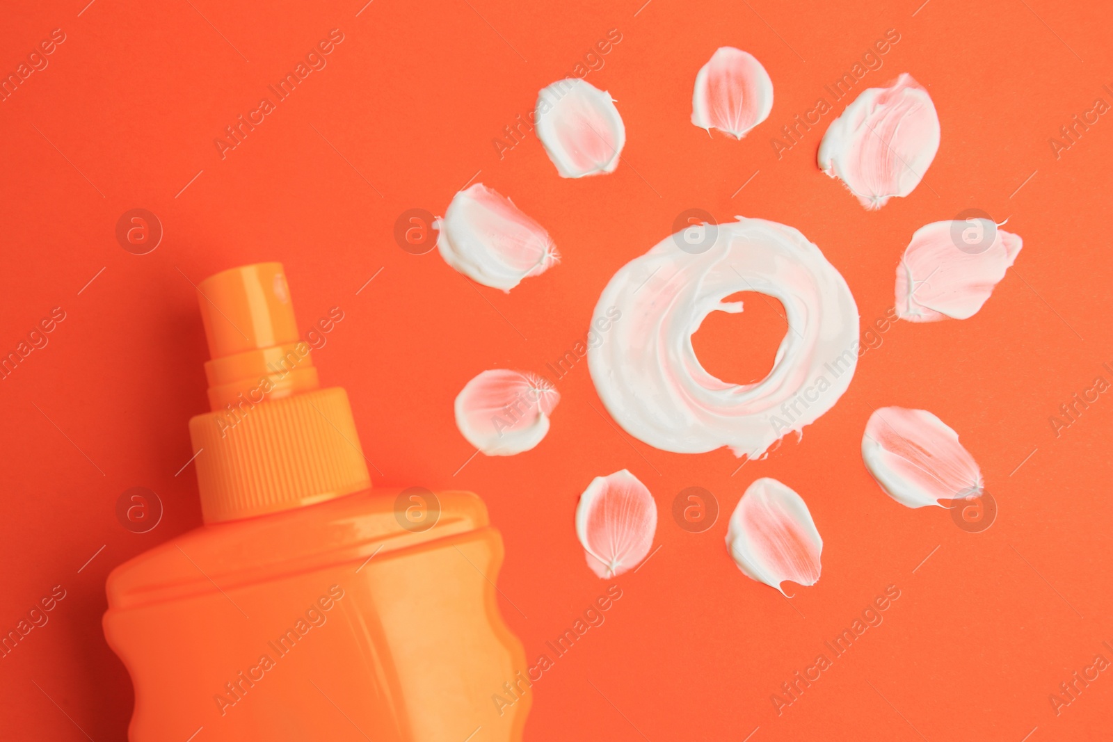 Photo of Drawing of sun and bottle with sunscreen on coral background, top view. Skin protection