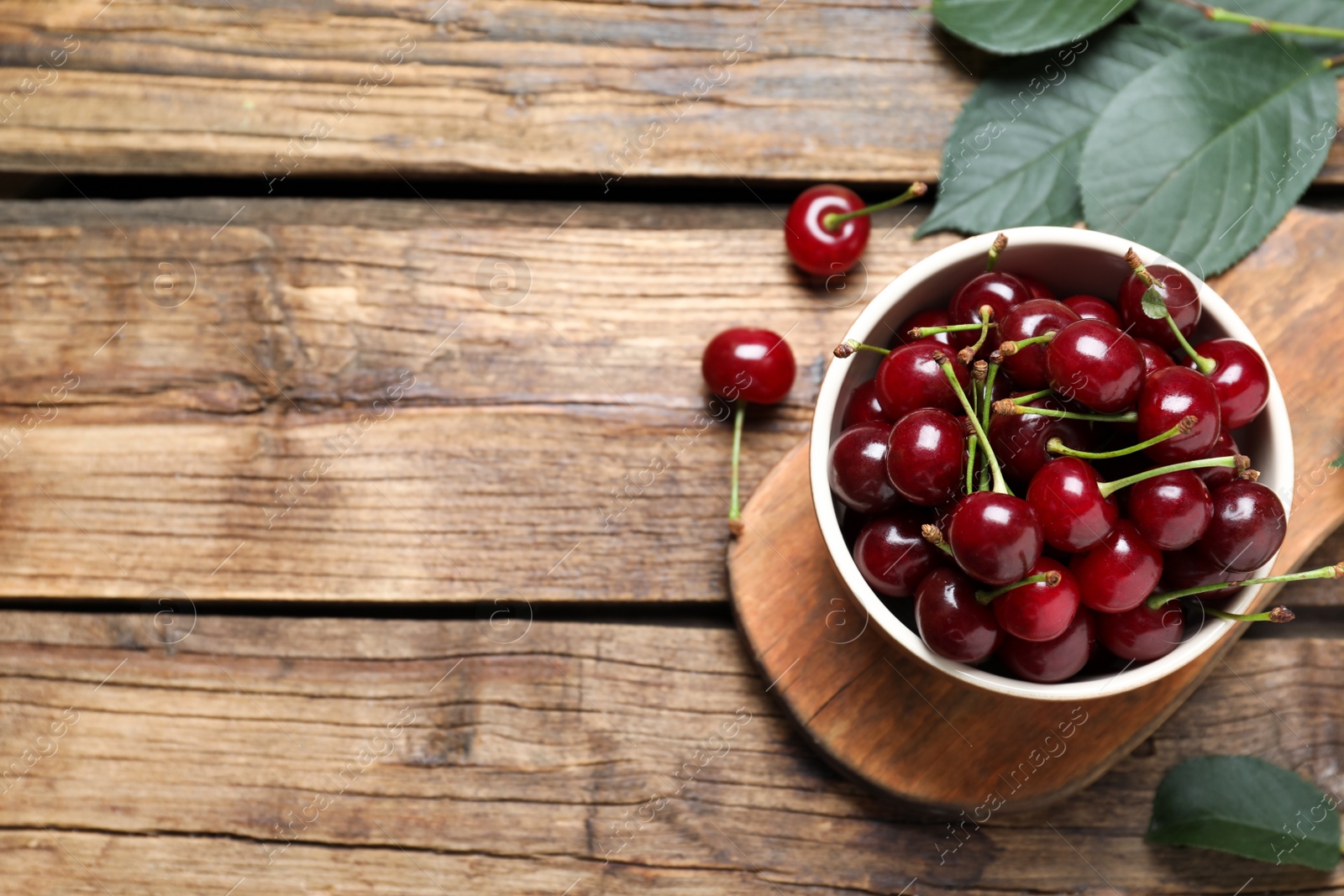Photo of Sweet juicy cherries on wooden table, flat lay. Space for text