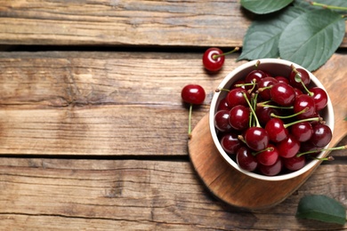 Sweet juicy cherries on wooden table, flat lay. Space for text