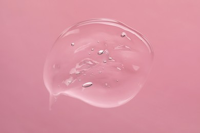 Sample of cleansing gel on light pink background, top view. Cosmetic product