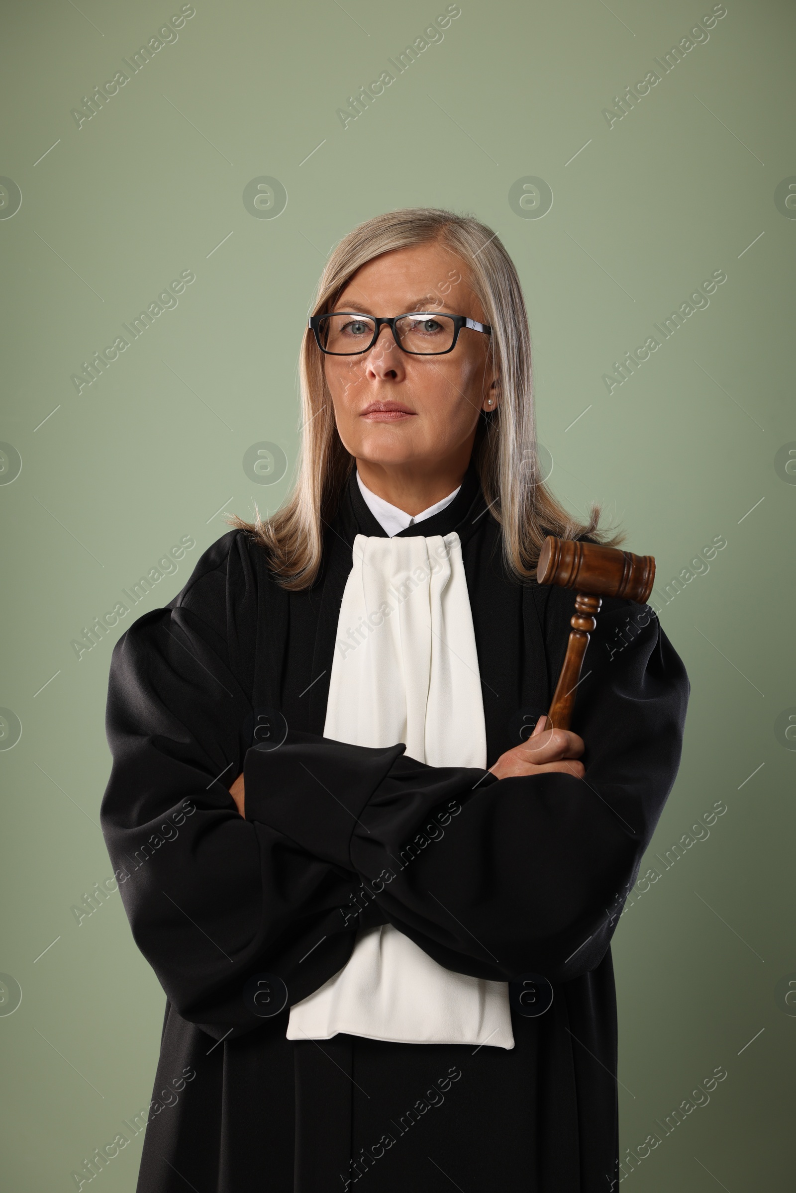Photo of Senior judge with gavel on green background