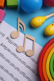 Photo of Tools for creating baby songs. Flat lay composition with wooden notes and maracas on light blue background