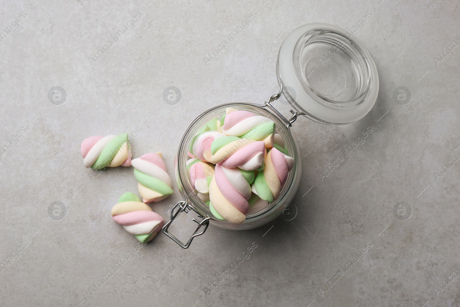 Photo of Glass jar with delicious colorful marshmallows on light grey table, flat lay