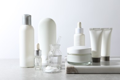 Photo of Organic cosmetic products and laboratory glassware on white table