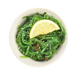 Photo of Japanese seaweed salad with lemon slice in bowl isolated on white, top view