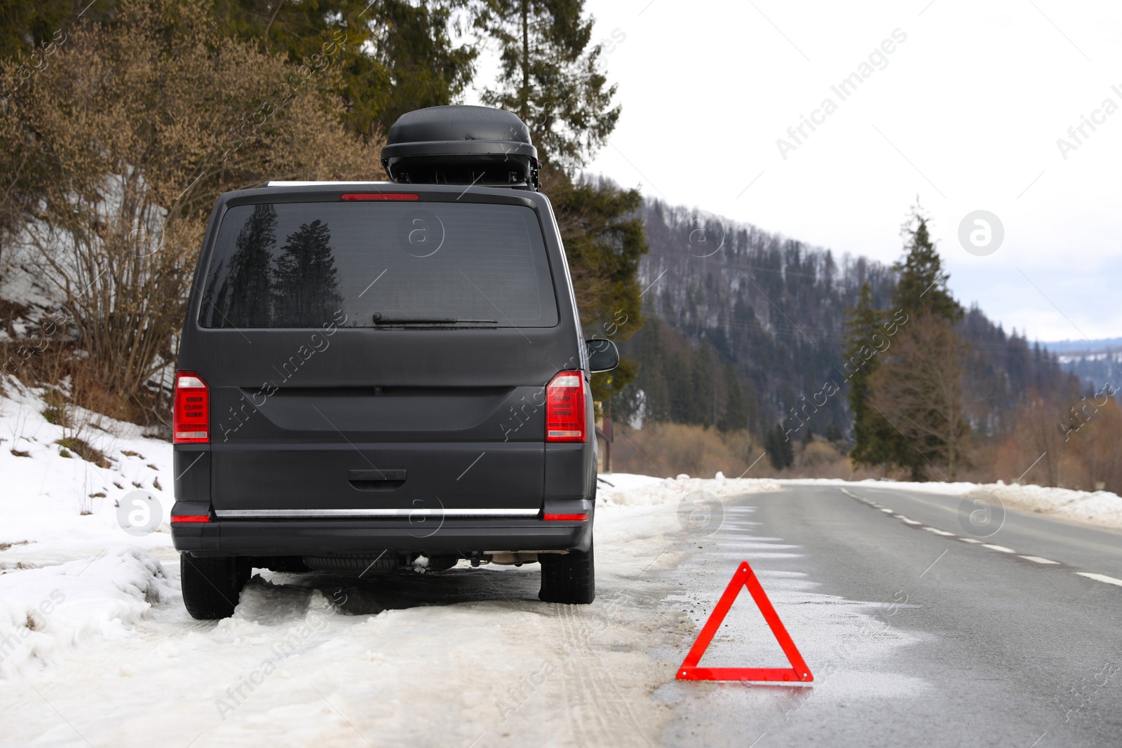 Photo of Emergency stop sign and broken car on winter day