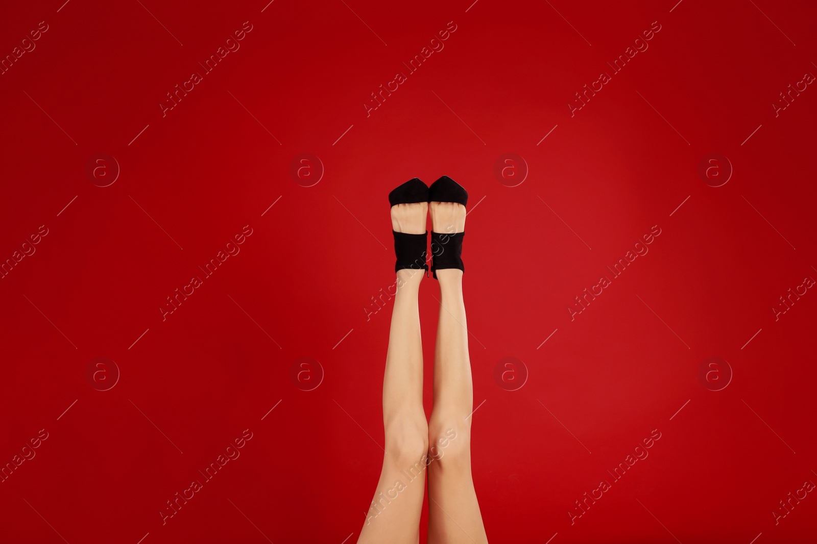 Photo of Woman in elegant shoes on red background