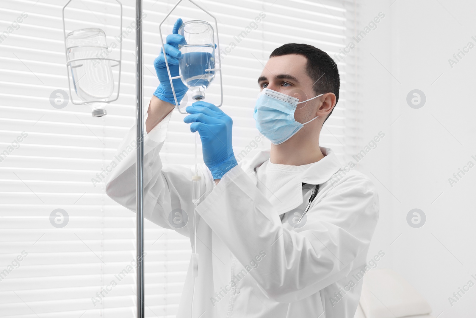 Photo of Doctor setting up IV drip in hospital