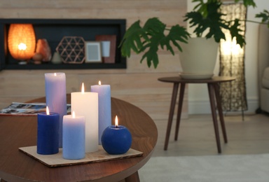 Photo of Burning candles on table in living room