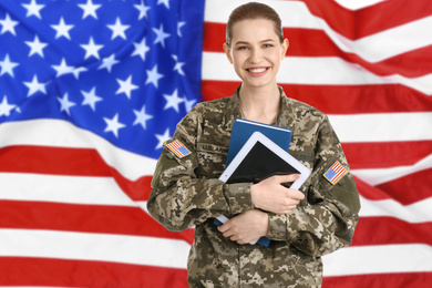 Image of Female soldier with tablet and American flag on background. Military service