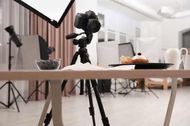 Photo of Professional equipment and composition with delicious dessert on wooden table in studio. Food photography