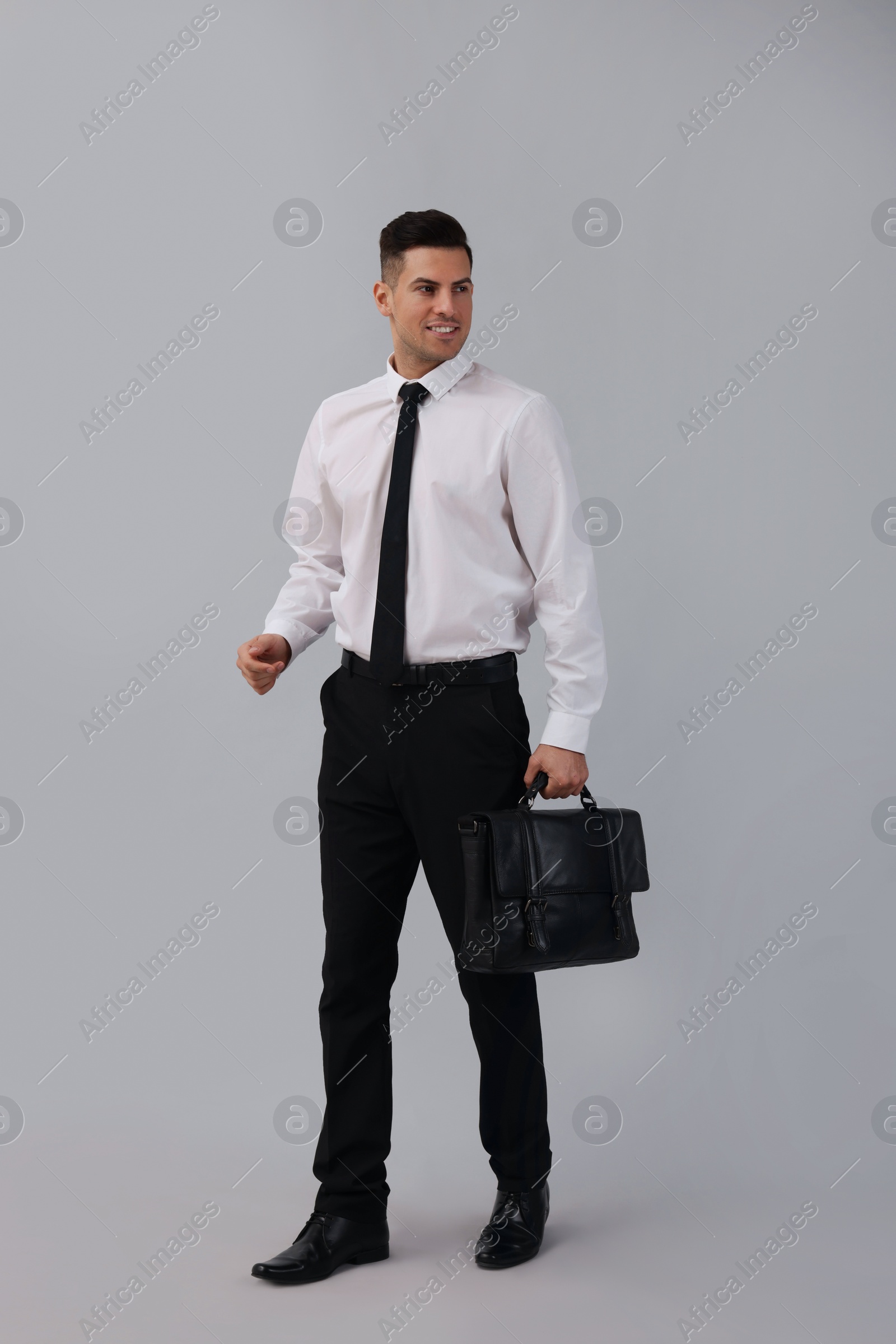 Photo of Businessman with stylish leather briefcase on light background