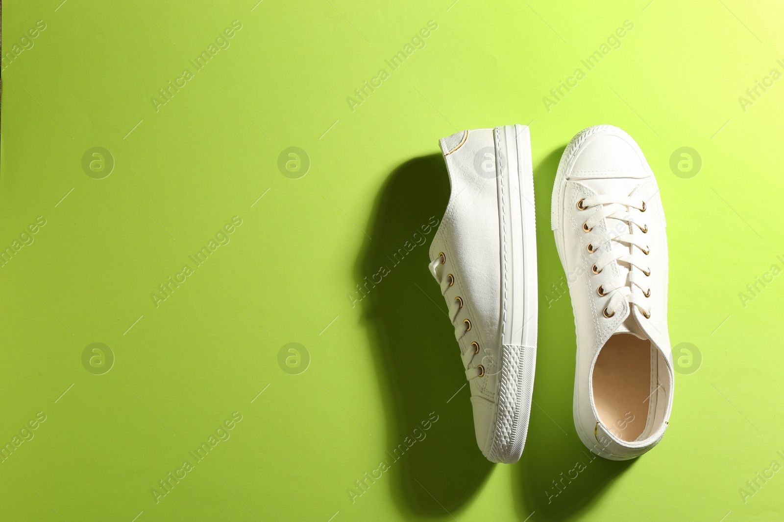 Photo of Pair of stylish sneakers on color background, top view with space for text