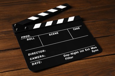 One clapperboard on wooden table, closeup view