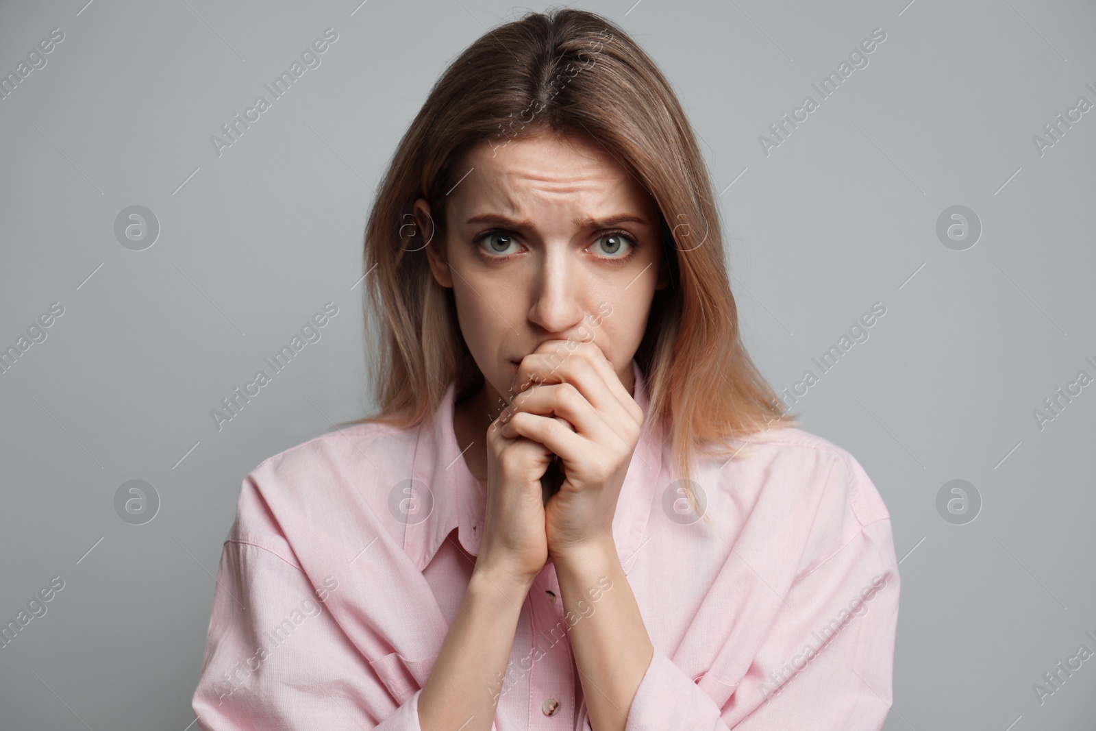 Photo of Young woman feeling fear on grey background