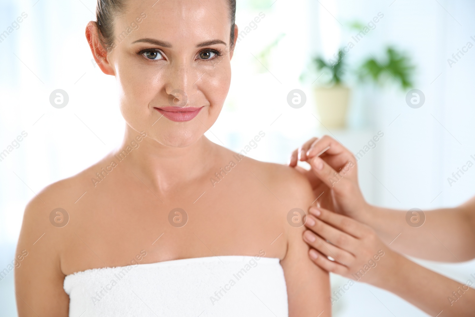 Photo of Young woman undergoing acupuncture treatment in salon