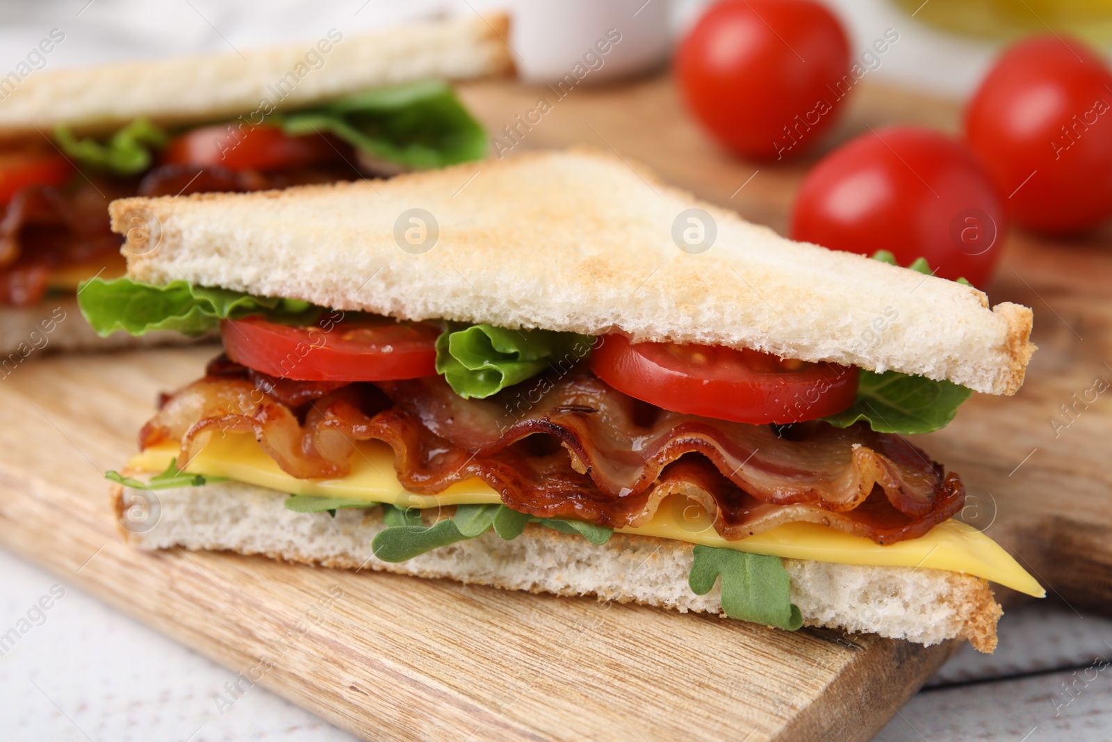 Photo of Delicious sandwich with fried bacon on wooden rustic table, closeup