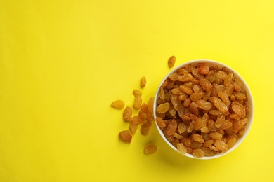 Photo of Bowl with raisins and space for text on color background, top view. Dried fruit as healthy snack