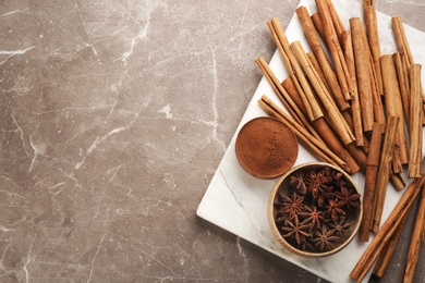 Aromatic cinnamon and anise on grey marble table, flat lay. Space for text