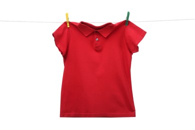 Photo of One red t-shirt drying on washing line isolated on white
