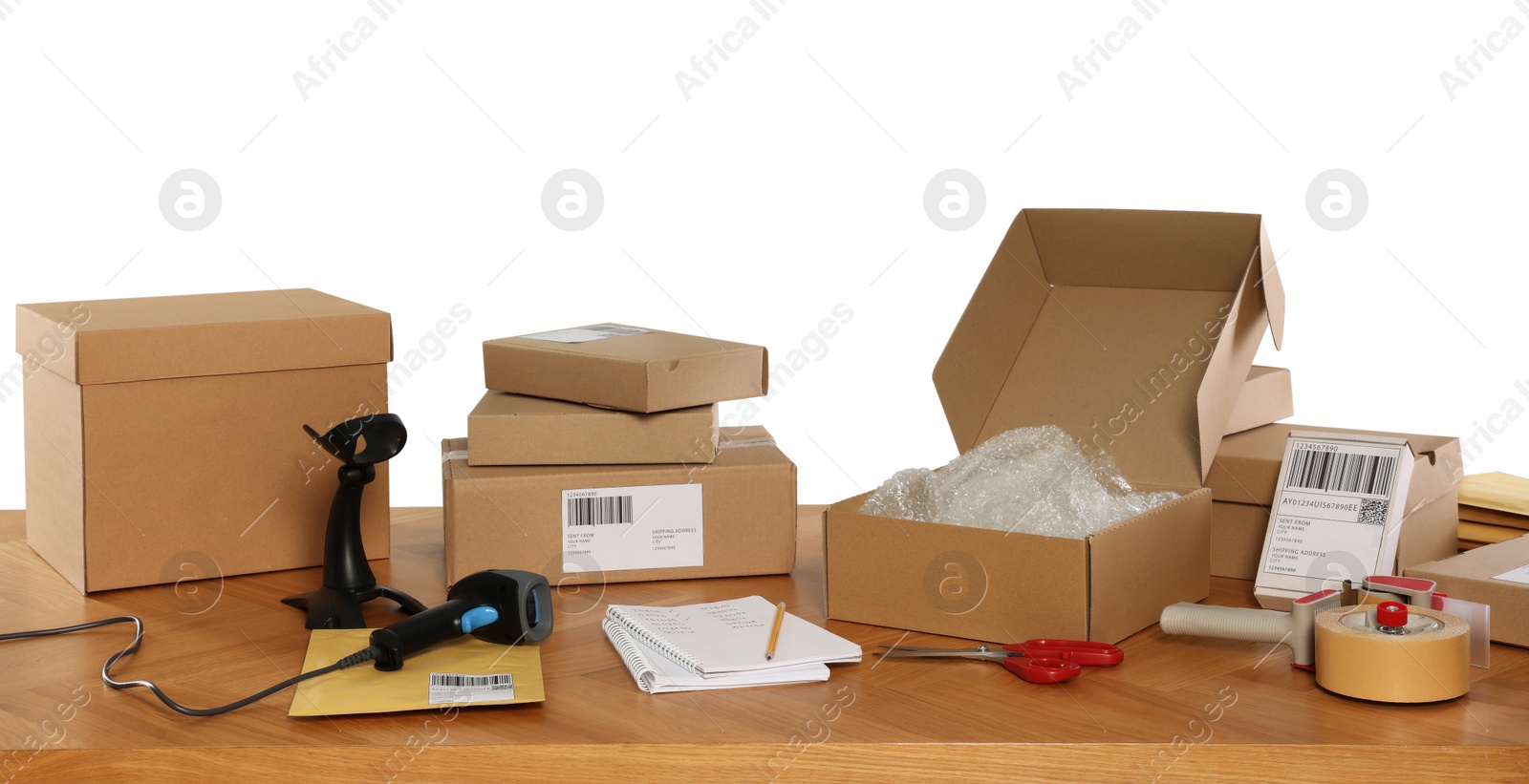 Photo of Parcels, barcode scanner and stationary on wooden table against white background. Online store