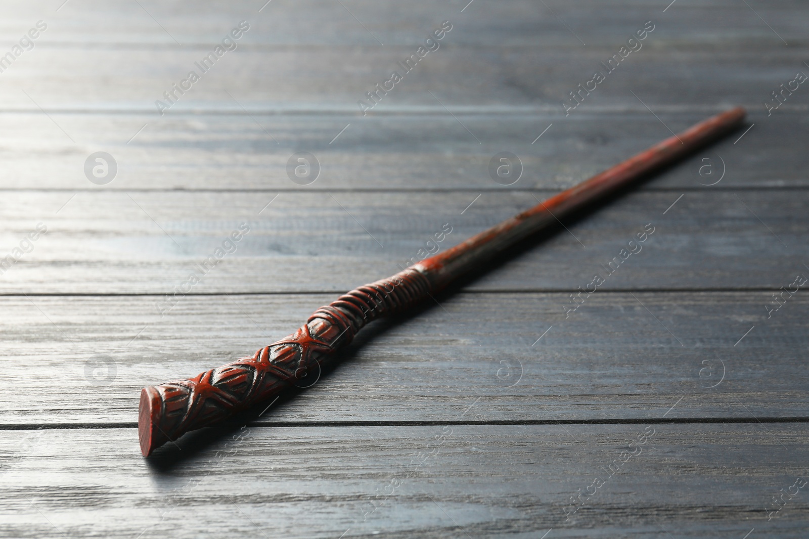 Photo of One old magic wand on grey wooden table