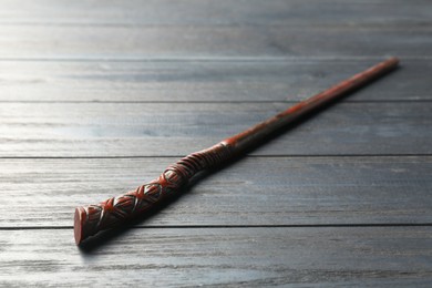 Photo of One old magic wand on grey wooden table