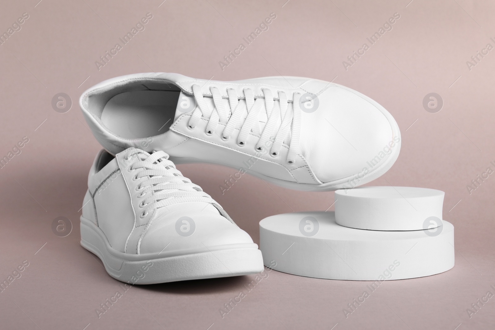 Photo of Pair of stylish white sneakers on grey background