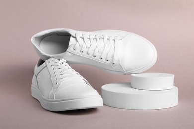 Pair of stylish white sneakers on grey background