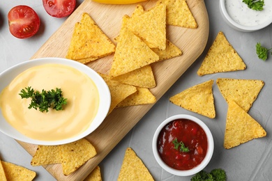 Photo of Flat lay composition with tasty Mexican nachos chips on grey table