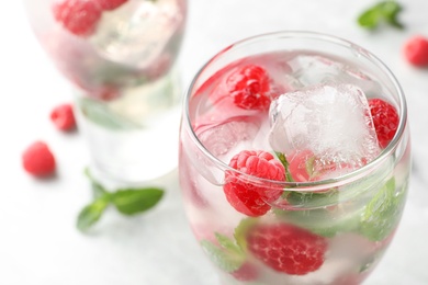 Photo of Glass of refreshing drink with raspberry and mint on table, closeup view. Space for text