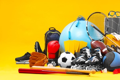 Photo of Many different sports equipment on yellow background