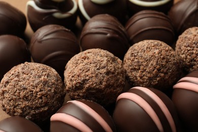 Photo of Many different delicious chocolate truffles, closeup view