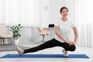 Morning routine. Happy woman doing stretching exercise at home