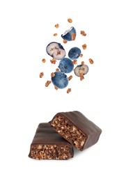 Tasty chocolate glazed protein bars and granola with blueberries falling on white background