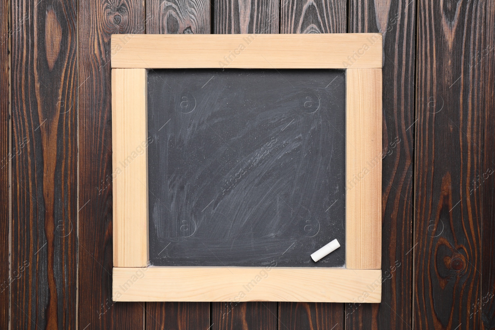 Photo of Blackboard with piece of chalk on wooden background, top view. Space for text