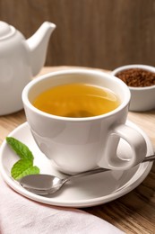 Photo of Freshly made buckwheat tea on wooden table, closeup