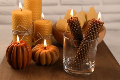 Beautiful burning beeswax candles on wooden table