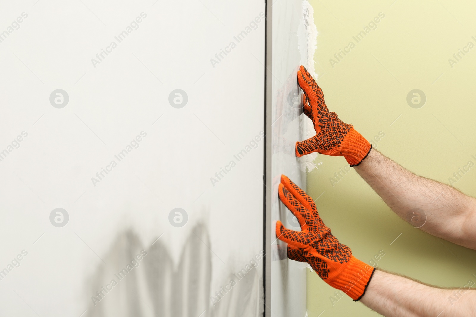 Photo of Man installing ceramic tile on wall, closeup. Building and renovation works
