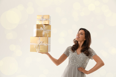 Beautiful woman with Christmas gifts on white background