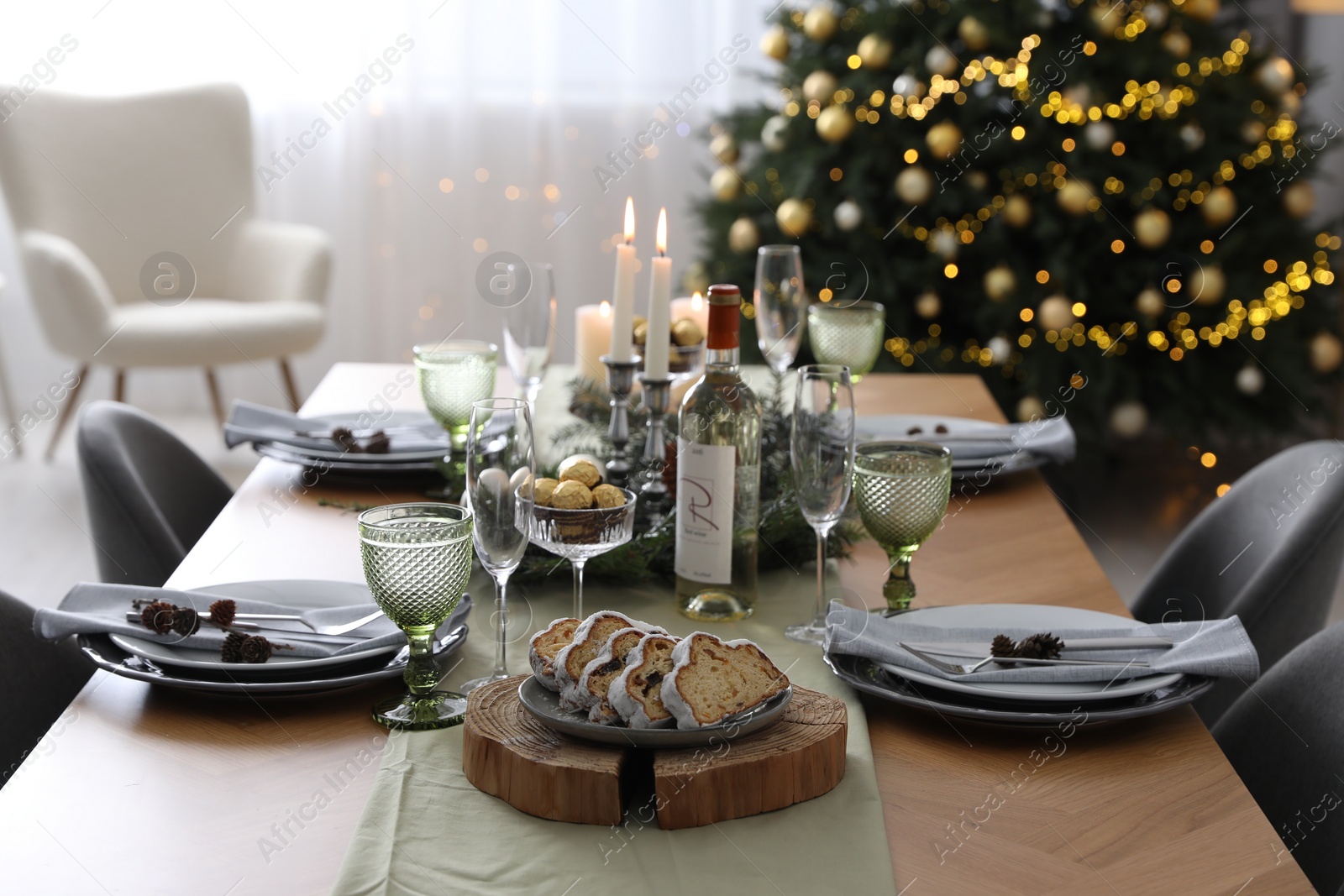 Photo of Christmas table setting with festive decor and dishware in room