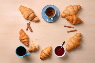 Flat lay composition with tasty croissants on wooden background